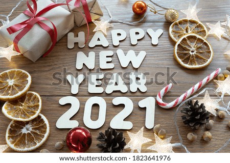 Happy new year 2021. Christmas composition. New year's layout on a dark wooden background. Cones, toys, gift, garland. High quality photo