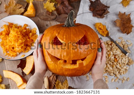 Making scary pumpkin jack for Halloween, holiday preparation Royalty-Free Stock Photo #1823667131