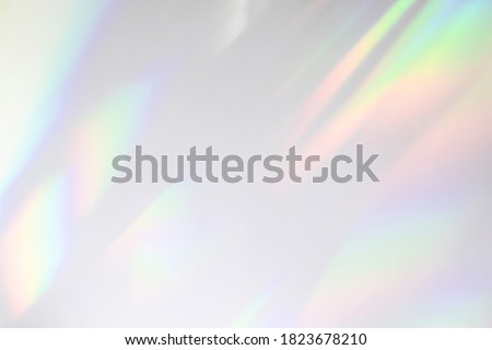 Blurred rainbow light refraction texture overlay effect for photo and mockups. Organic drop diagonal holographic flare on a white wall. Shadows for natural light effects Royalty-Free Stock Photo #1823678210