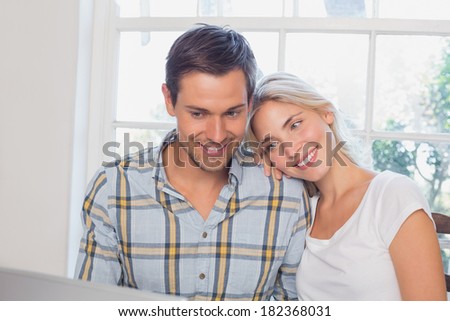 Portrait of a happy loving young couple with laptop at home