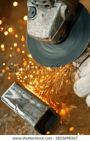 Processing and grinding of a metal part using an angle grinder. Many sparks fly out from under the disk.