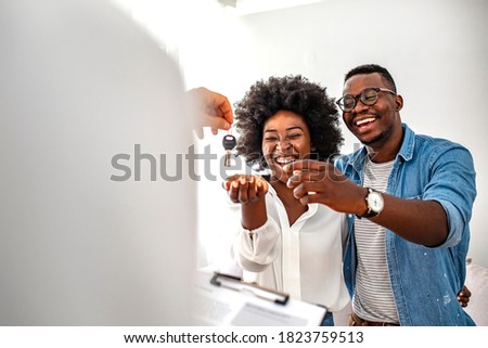 Young couple in love starting family life, got a chance of acquiring independent home ownership, given key from new apartment, social renting, purchasing new apartment, meeting with real estate agent Royalty-Free Stock Photo #1823759513