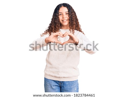 Beautiful kid girl with curly hair wearing casual clothes smiling in love doing heart symbol shape with hands. romantic concept. 