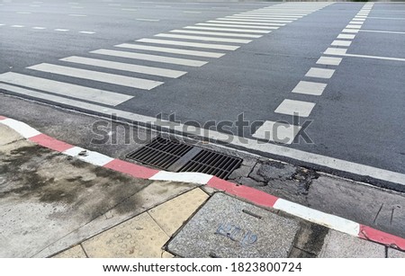 A  photograph of the edge of 
a pedestrain crossing at a pedestrian crossing.