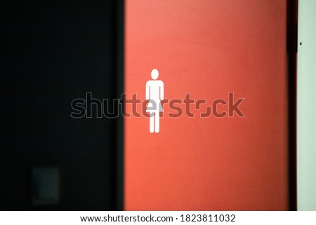 women's toilet sign on red