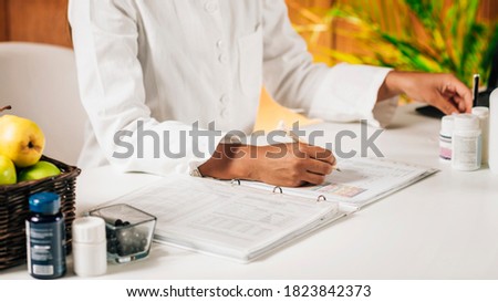 Functional medicine doctor taking notes for personal health report Royalty-Free Stock Photo #1823842373