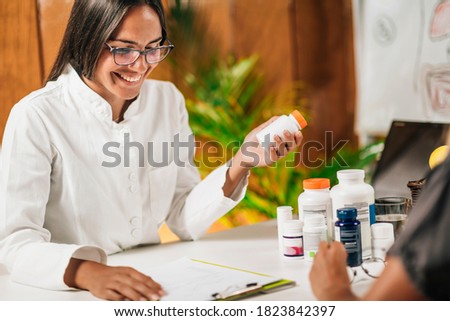 Functional medicine female practitioner recommending dietary supplement to a client Royalty-Free Stock Photo #1823842397