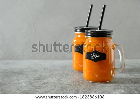 Halloween Pumpkin Cocktail with spice and carrot juice on gray background with text - Boo. Space for text.