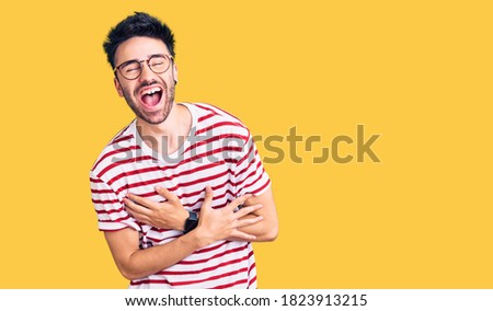 Young hispanic man wearing casual clothes smiling and laughing hard out loud because funny crazy joke with hands on body.  Royalty-Free Stock Photo #1823913215
