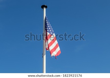 An American flag on a pole waving in the sky