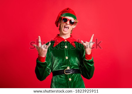 Photo of crazy funky elf guy in trend sunglass show horns symbol isolated over red shine color background