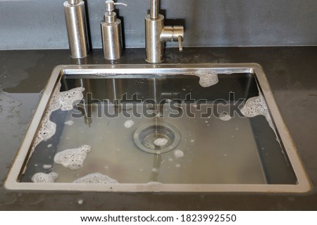 Overflowing kitchen sink, clogged drain. Plumbing problems. Royalty-Free Stock Photo #1823992550
