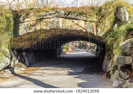 A Beautiful Old Stone Arch and an Alley Below it in Central Park. Natural Environment with Bare Trees on Winter. Manhattan, New York City, USA.