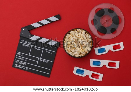 Movie clapper board, popcorn bowl, 3d glasses, film reel on red background. Entertainment industry. Top view. Flat lay