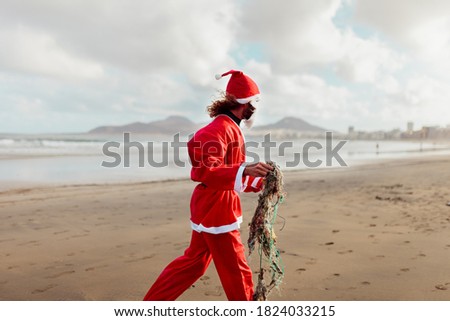 Man cleaning the beach of plastics and fishing nets