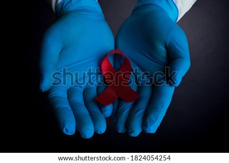 A medical worker is holding a sign of the fight against AIDS close up