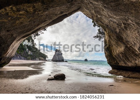 Ocean tide in the Cathedral Cave. Mirror reflections of clouds in wet sand. Travel to New Zealand. The concept of exotic, ecological and photo tourism