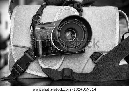 Photography; digital mirrorless camera with lens and camera bag