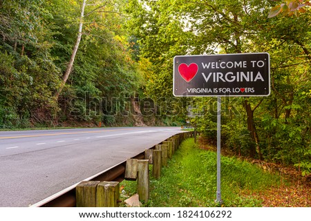Welcome to Virginia sign located at the Maryland, Virginia state border at Purcellville, Virginia. The black sign has a red heart shape and 'Virginia is for lovers' slogan underneath. Royalty-Free Stock Photo #1824106292
