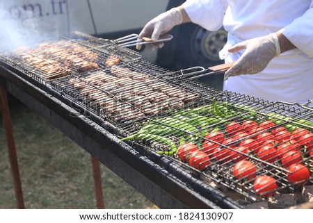 The Chef prepares meat on the barbecue.
