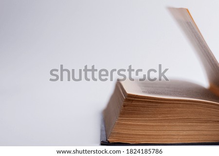 Photo of a part of a book on a white background with protruding pages.