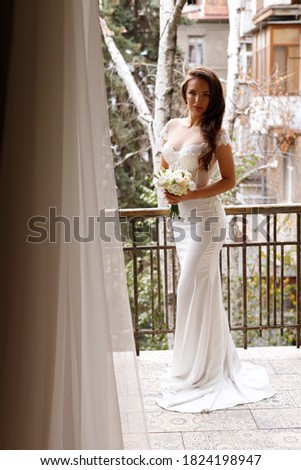 bride in a white wedding dress with a bouquet. Wedding makeup and hairstyle