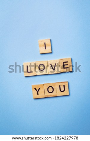 The inscription on wooden cubes I love you, laid out on a blue background, top view