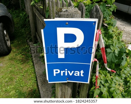 A closeup of a plate on a wooden fence with an inscription in German "Privat", translation: "Private"