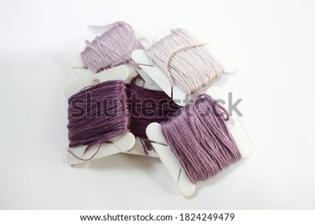 Sewing thread in violet color with white background
