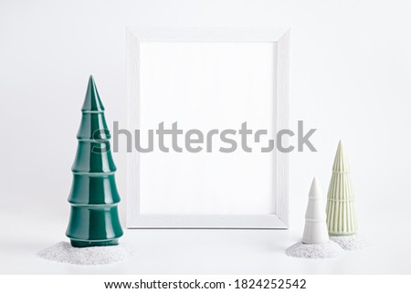 Christmas mockup frame with ceramic Christmas trees and white baubles on white background. Minimalistic Christmas card with modern decor, copy space