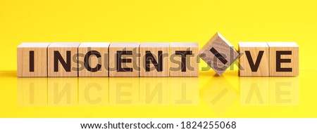 Word INCENTIVE is made of wooden building blocks lying on the table and on a light yellow background. Concept. Royalty-Free Stock Photo #1824255068