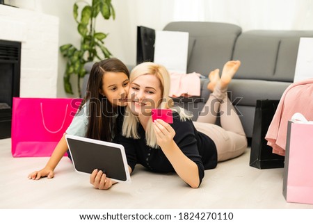 Mother and daughter is using tablet for buying thing online black Friday