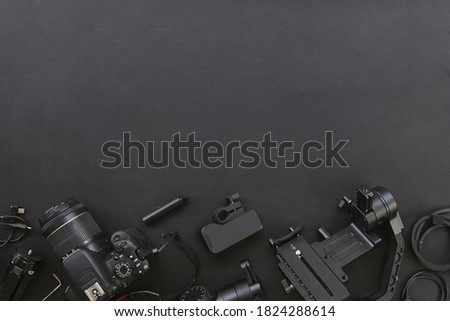 top view of work space photographer with digital camera and accessory on black background