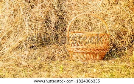 Wicker picnic basket and a haystack - beautiful rural background in Sunny summer day