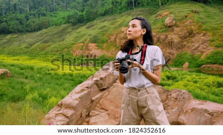 Young woman taking photos of natural view.