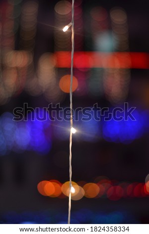 A String of LED light bulb with multiple blurred lights in background during festival if Diwali in India