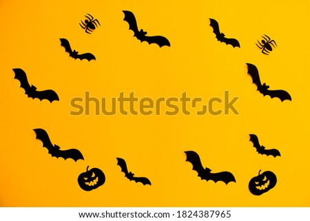 Frame of paper silhouettes of bats, scary pumpkins and spiders on orange background. Trick or treat Halloween holiday banner template with copy space.