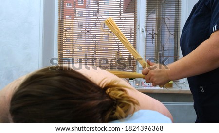 Anti-cellulite massage with bamboo sticks for a fat woman. Aggressive fight against fat. Spa treatment. High quality photo
