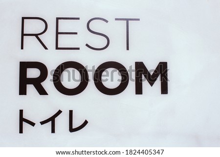 The words Rest room on the concrete wall with Japanese languages mean rest room