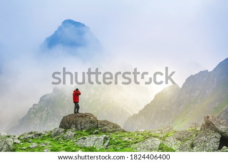 Photographer on top of the mountain taking pictures of misty mountains in Slovakia.