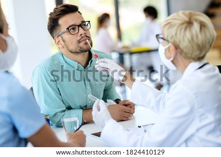 Young man getting PCR test for coronavirus during appointment at doctor's office.  Royalty-Free Stock Photo #1824410129
