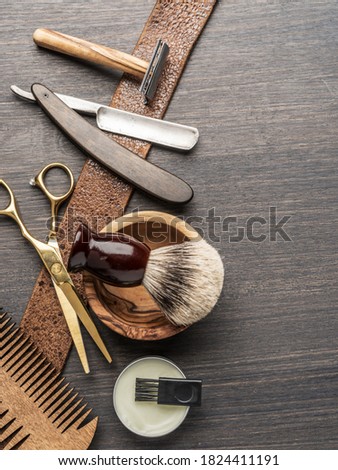 Classic grooming and hairdressing tools on wooden background. Top view on barbershop instruments  laying on dark wooden table.