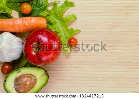 Fresh fruit and vegetables on a wooden cutting board
