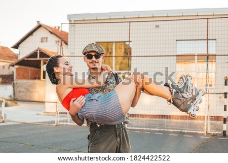 Young man holds his girlfriend in his arms