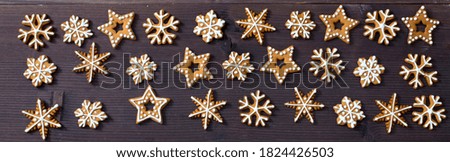 Top above high angle closeup overhead view of nice christmas decoration. Gingerbread cookies in the form of snowflakes, arrows, stars and hearts on a wooden brown table
