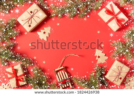 Christmas background with gift boxes, sleigh, Xmas tree, snowflakes and handmade stars on red with copy space. New year card. Flat lay