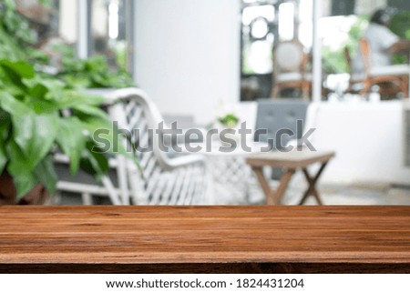 Empty wooden table with blurred background of cafe or restaurant.