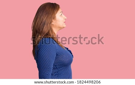 Middle age latin woman wearing casual clothes looking to side, relax profile pose with natural face with confident smile. 