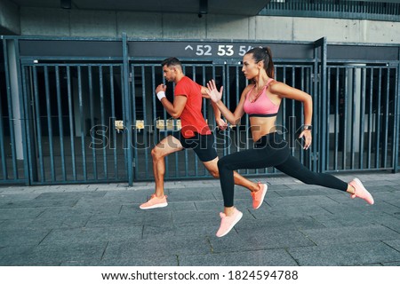 Full length of two athletes in sports clothing hovering in long jump while practicing outdoors Royalty-Free Stock Photo #1824594788