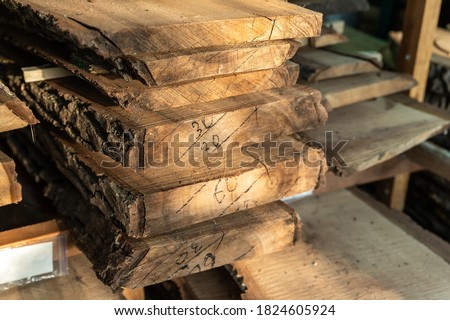 Air-drying sawn wooden plank slab pile under canopy at home backyard prepared for carpentry diy hobby. Woodshed store at house yard. Timber material stacked for woodworking Royalty-Free Stock Photo #1824605924